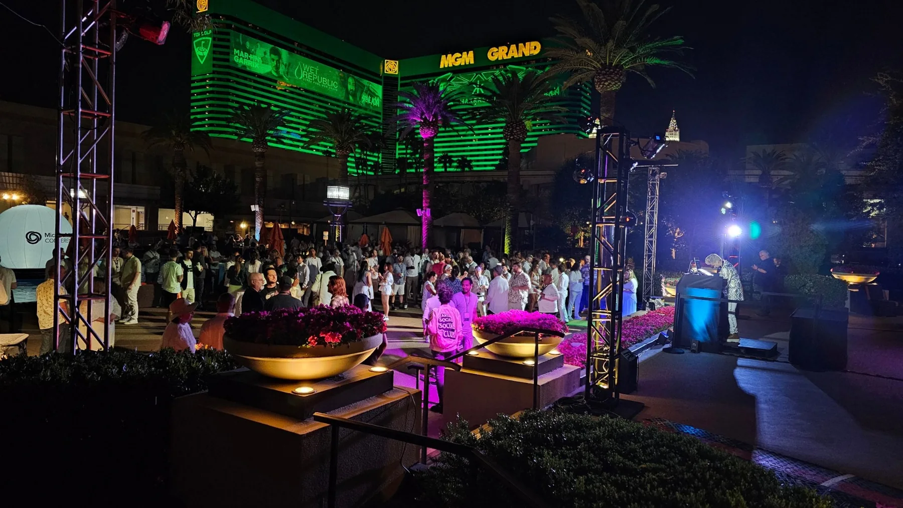 Outdoor corporate networking reception at MGM Grand with attendees, stage lighting, and evening event energy