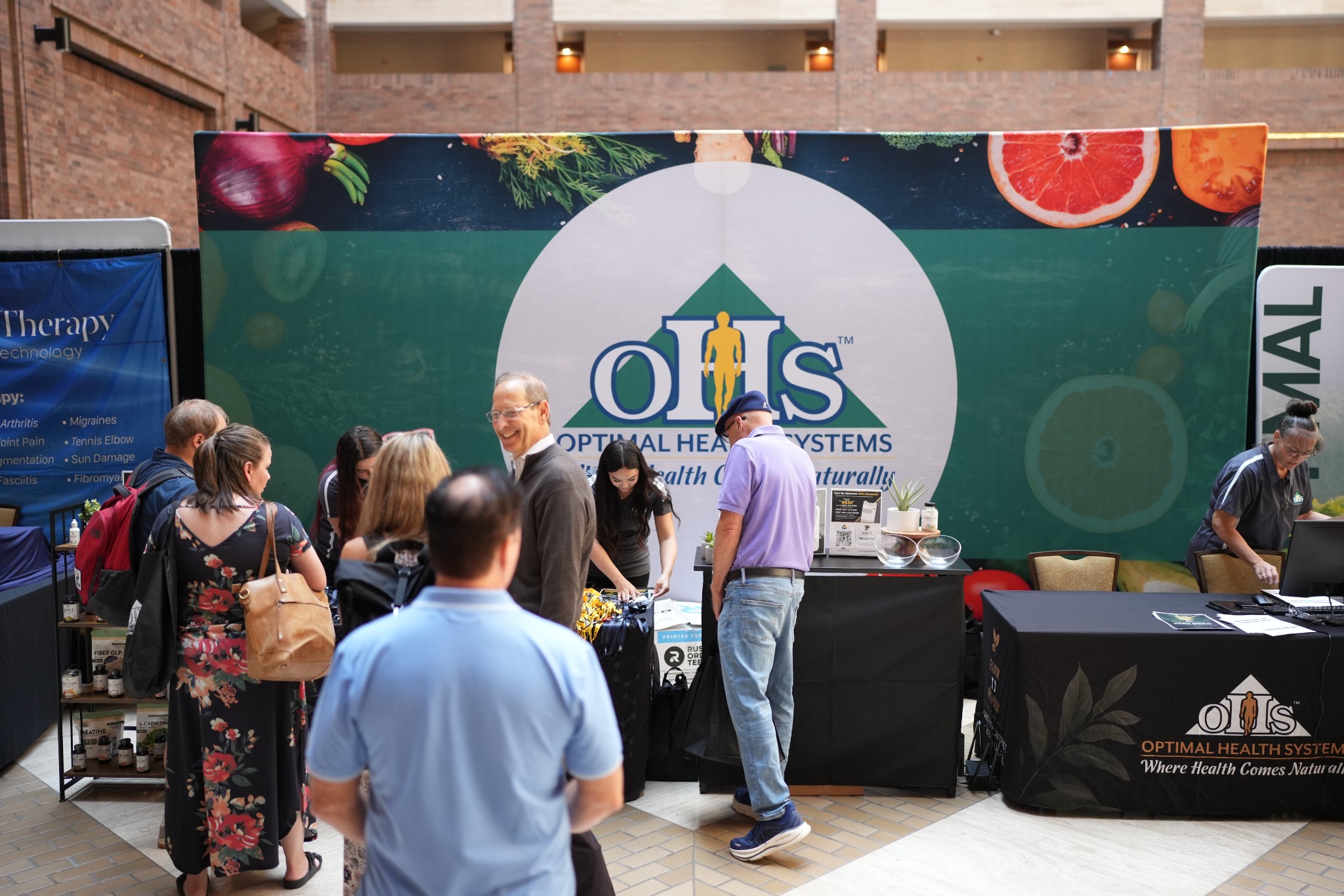 Conference expo booth with attendees gathered around a branded exhibitor activation